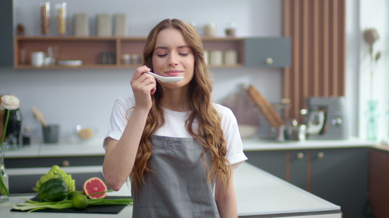 woman holding spoon and savoring