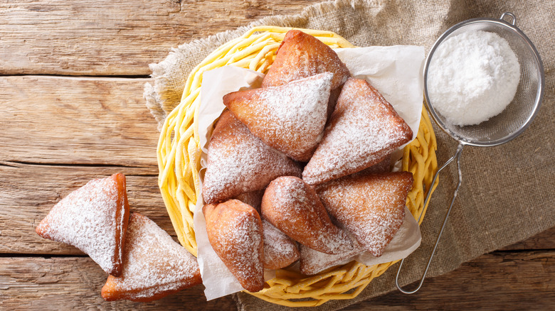 Wicker basked full of mandazi with powdered sugar