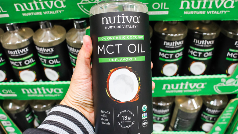 Hand holding a bottle of Nutiva MCT oil 