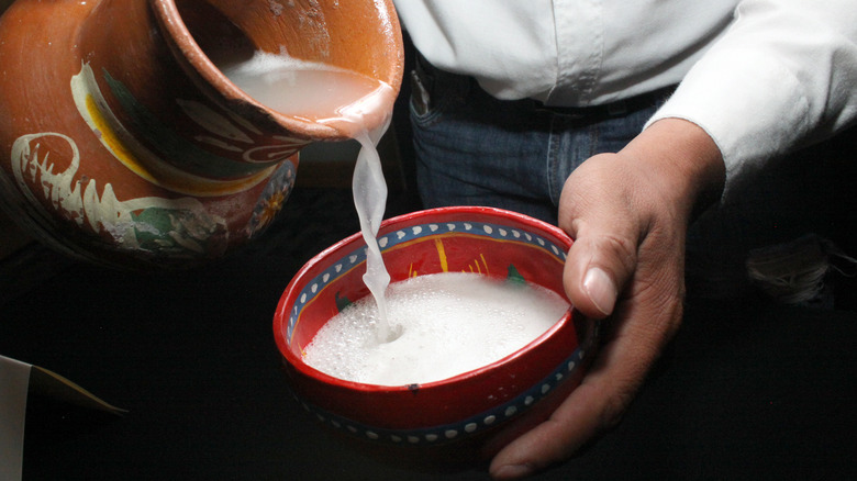 man pouring pulque