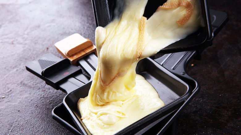 melted raclette cheese scraped into black dish