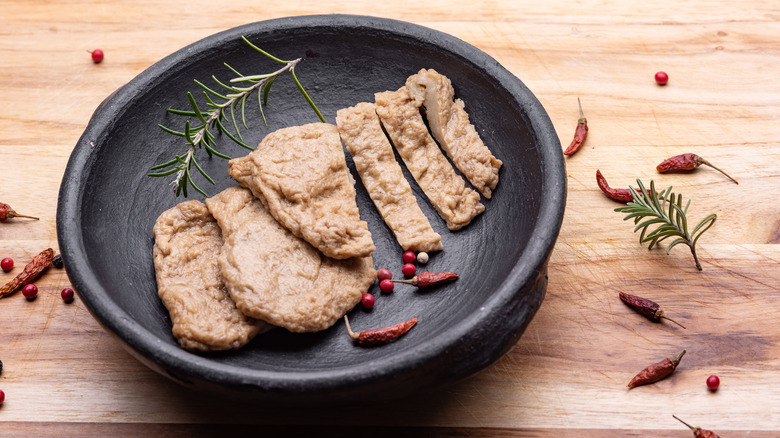 Strips of cut-up seitan in gray stone bowl