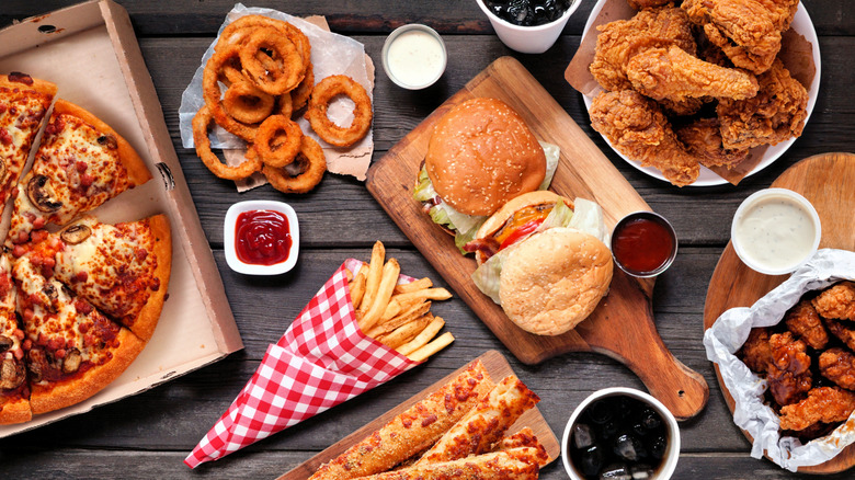 Pizza, a burger, onion rings, bread sticks, fries, and fried chicken