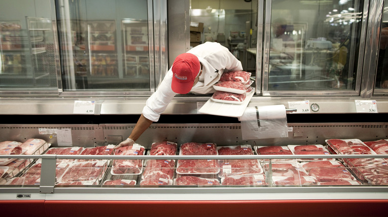 Butcher stocking Costco meat section