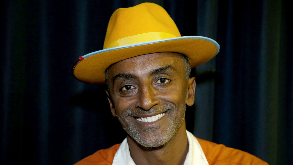 Chef Marcus Samuelsson smiles wearing a hat