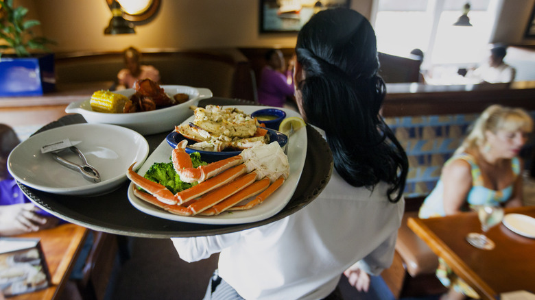 server carrying tray of crab legs at Red Lobster