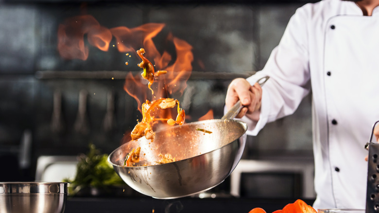 A chef cooking with a wok