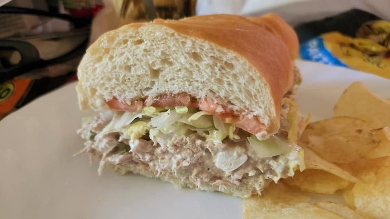 Closeup of a halved tuna salad sandwich with chips