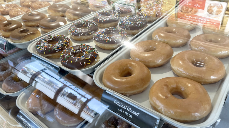 Various Krispy Kreme doughnuts in glass display case.
