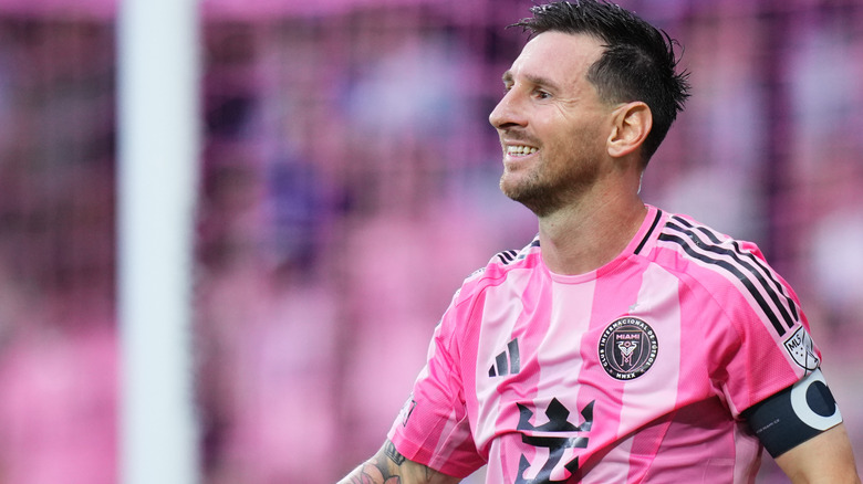 Lionel Messi in profile smiles on the field in Inter Miami kit