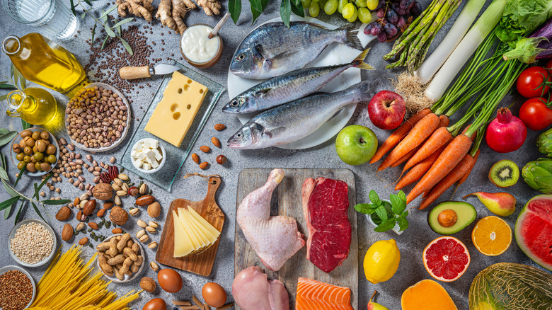 Assortment of whole fish, fruits, vegetables, nuts, and olive oils