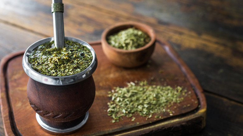 Traditional yerba mate setup with leaves on wooden board