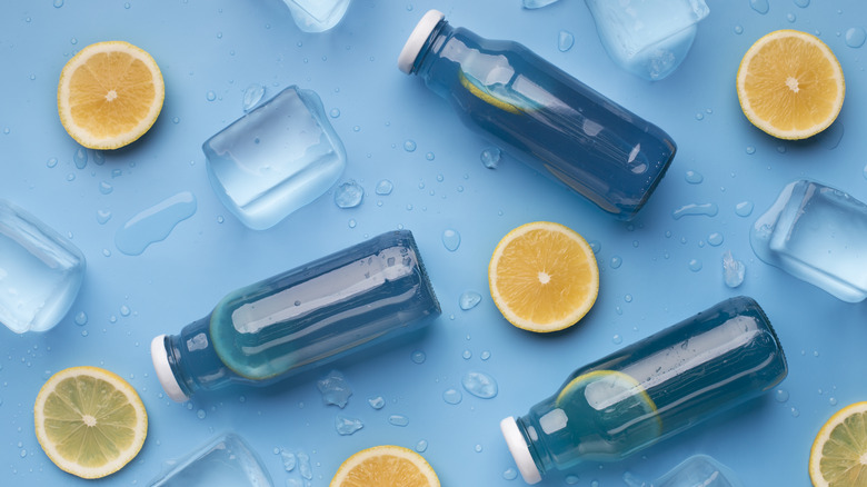 Bottles of blue liquid with lemon slices and ice cubes