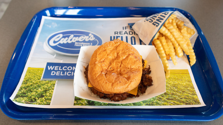 Culver's ButterBurger sits on a tray next to French fries.