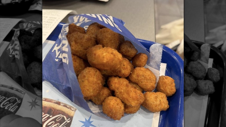 Culver's cheese curds spilling out of bag onto tray on restaurant table
