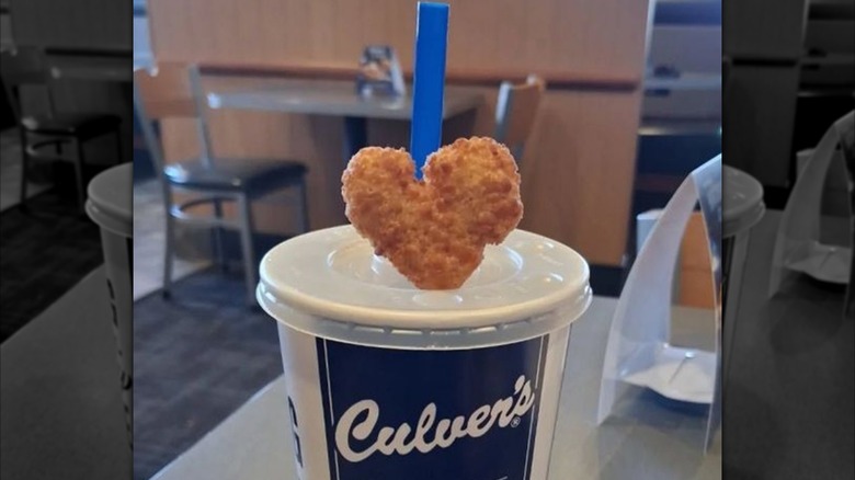 A heart-shaped cheese curd leaning against the straw of a Culver's soft drink