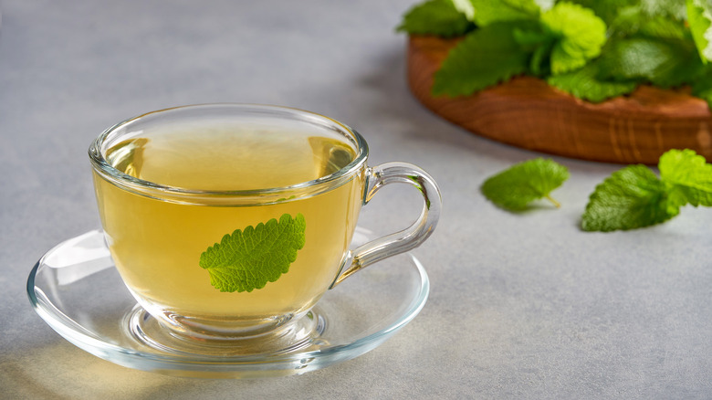 A tea cup with a leaf in it