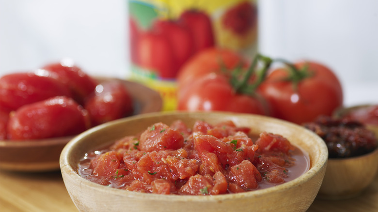 bowl of chopped tomatoes with peeled, whole and canned tomatoes out of frame