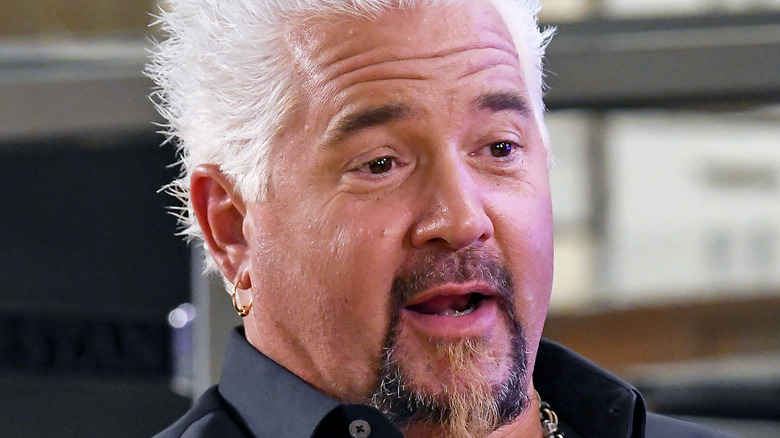 guy fieri seated at a table