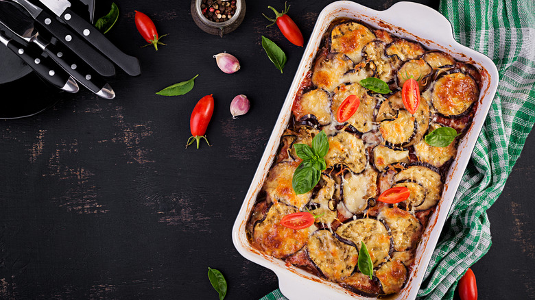 Baked Eggplant Parmesan in casserole dish with ingredients