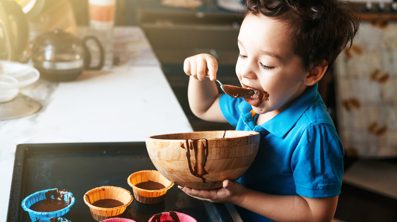 child baking brownies in kitchen