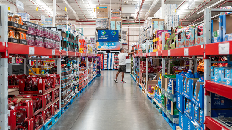 A shopper browses items in a Sam's Club aisle