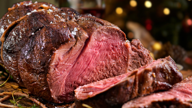 A roasted elk sirloin served medium rare with slices carved off