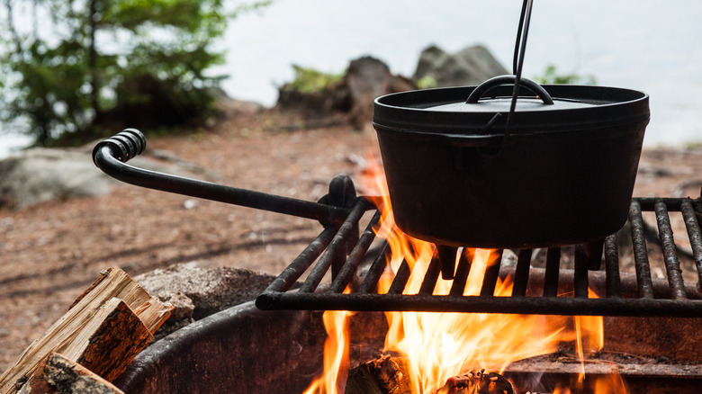 Cast iron Dutch oven on grates over a campfire