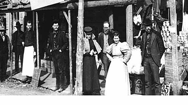 Black and white photo from 1898 shows a crowd standing around a Klondike region gold rush restaurant