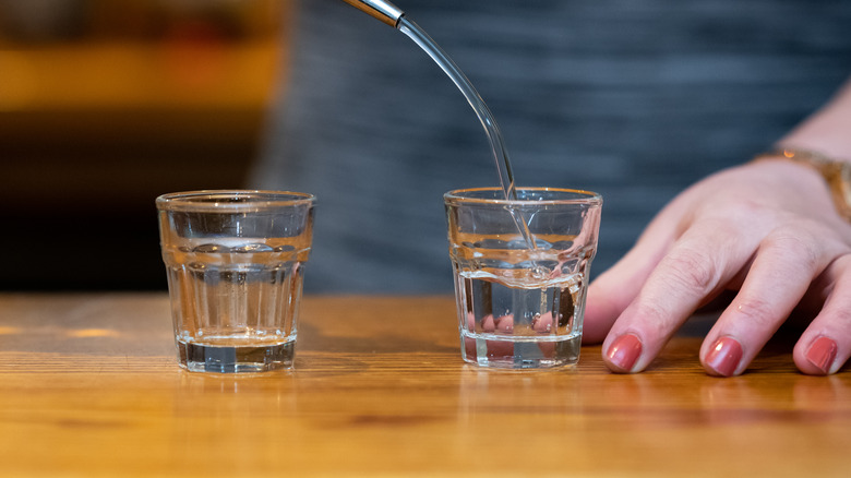 liquid being poured into shot glasses