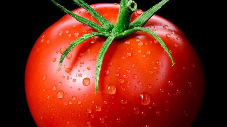 Closeup photo of red tomato with green stem