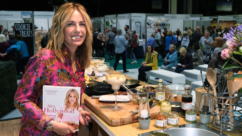Alex Hollywood smiling with her cookbook at cooking convention