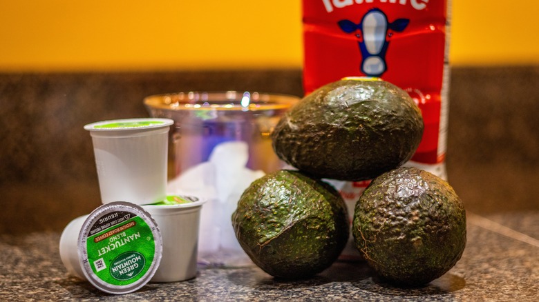 Keurig K-cups next to avocados, milk, and glass of ice