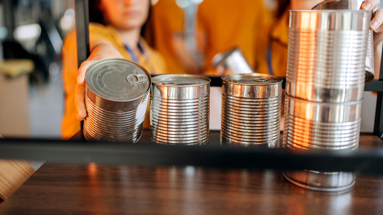 People reaching for canned food