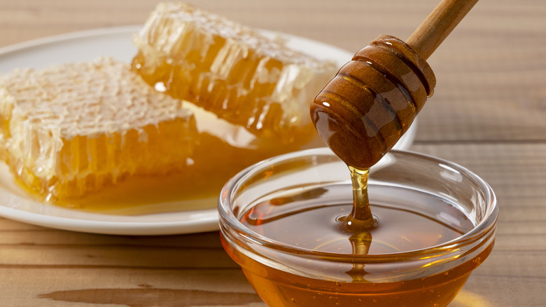 Honey dripper and honeycomb on plate