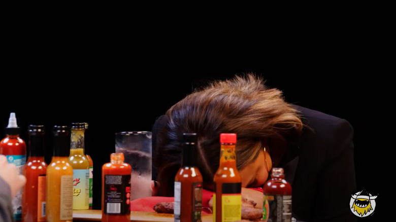 Chrissy Teigen puts her head down on the "Hot Ones" table