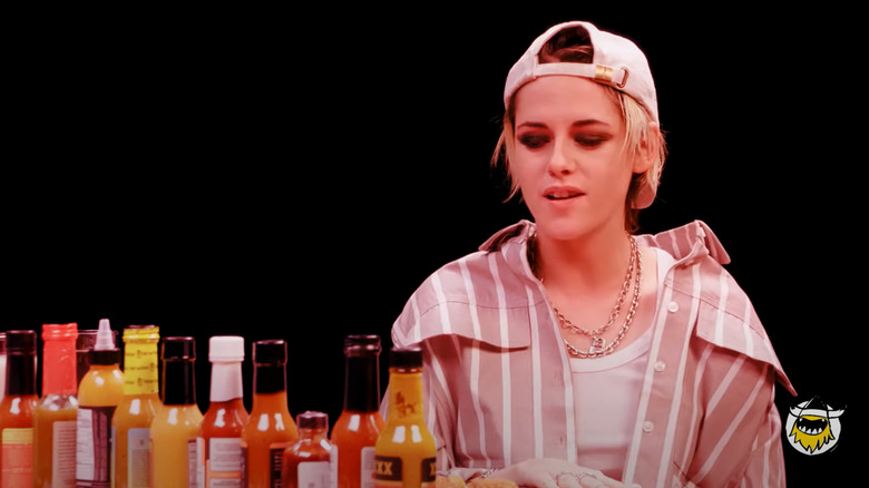 the hot sauce lineup in front of Kristen Stewart