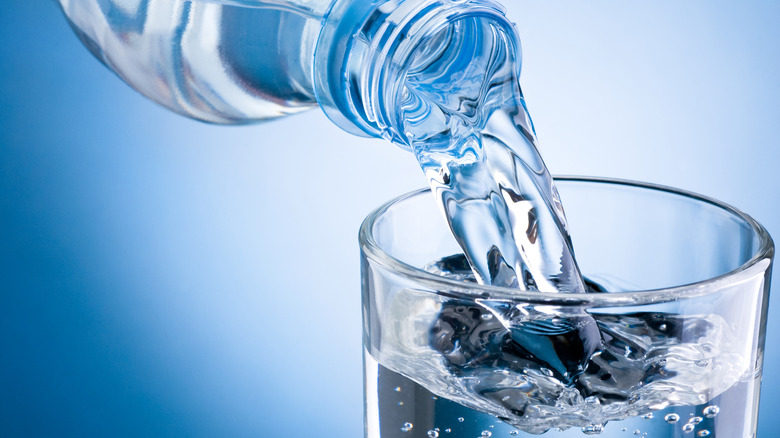 Pouring water bottle into glass