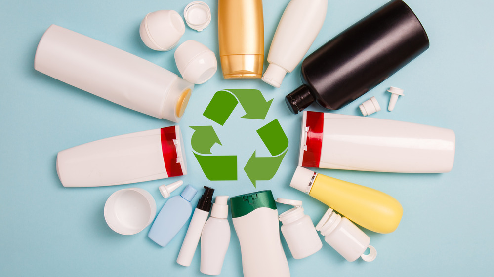 plastic bottles around recycling sign 