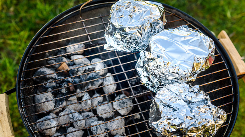 Food wrapped in aluminum foil on grill