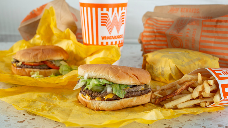 A Whataburger combo meal with three burgers, fries, and a soda