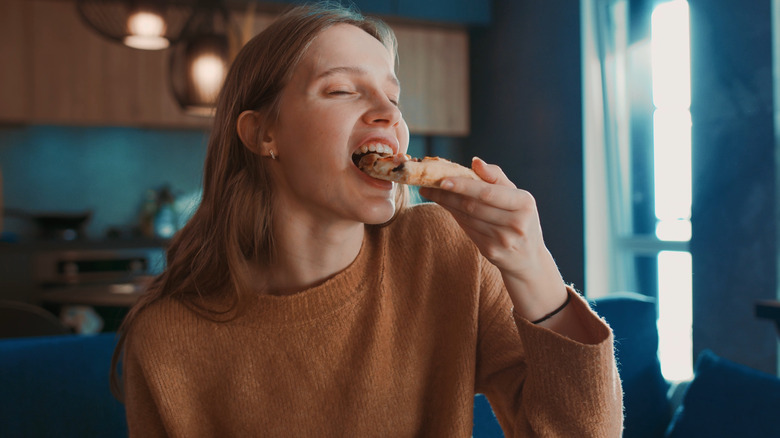 Woman taking a bite of pizza
