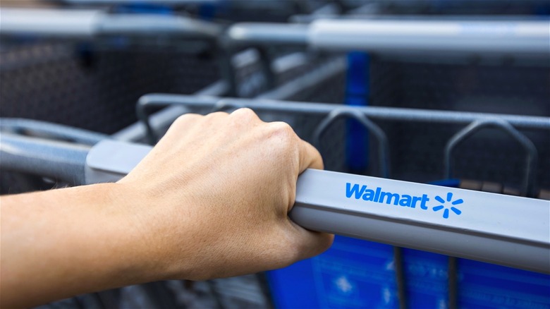 Hand grabbing Walmart shopping cart
