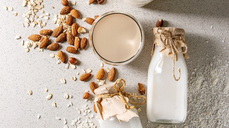 dairy milk alternative, oats and almonds in background