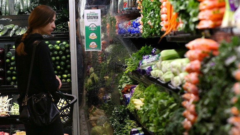 Woman in cold vegetable section Whole Foods