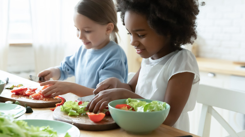 Girls preparing salad bowls 