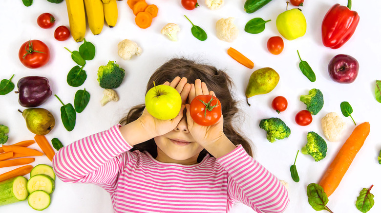 Girl smiling with colorful vegetables and fruits 