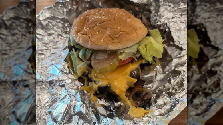 A Five Guys veggie sandwich, showing the mushrooms, tomatoes, onions, and lettuce inside