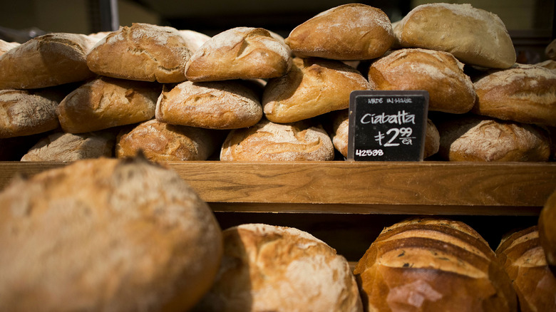 Whole Foods ciabatta rolls piled on shelf 