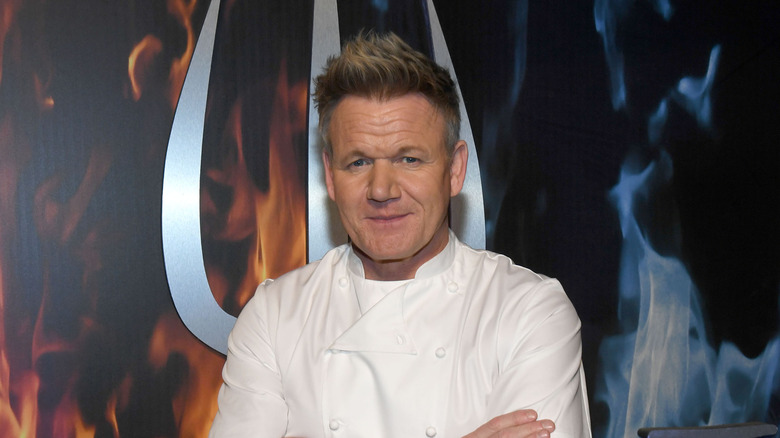 Gordon Ramsay posing in front of Hell's Kitchen sign